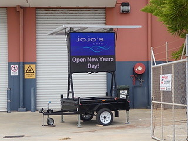 Full colour LED hire trailer sign for Jojo's Cafe reading Open New Years Day