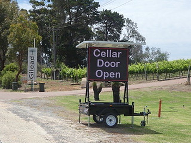 LED hire trailer sign reading Cellar Door Open beside a vineyard