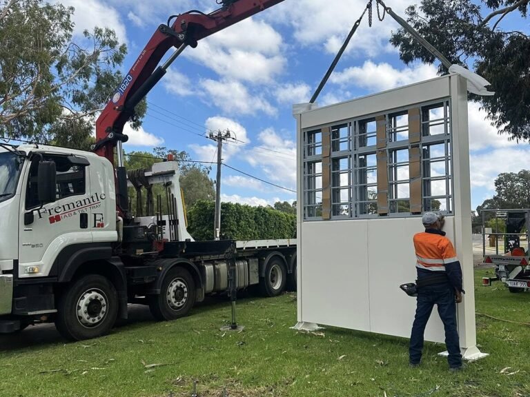 iCatcher crew installing a custom LED pylon sign with a crane truck