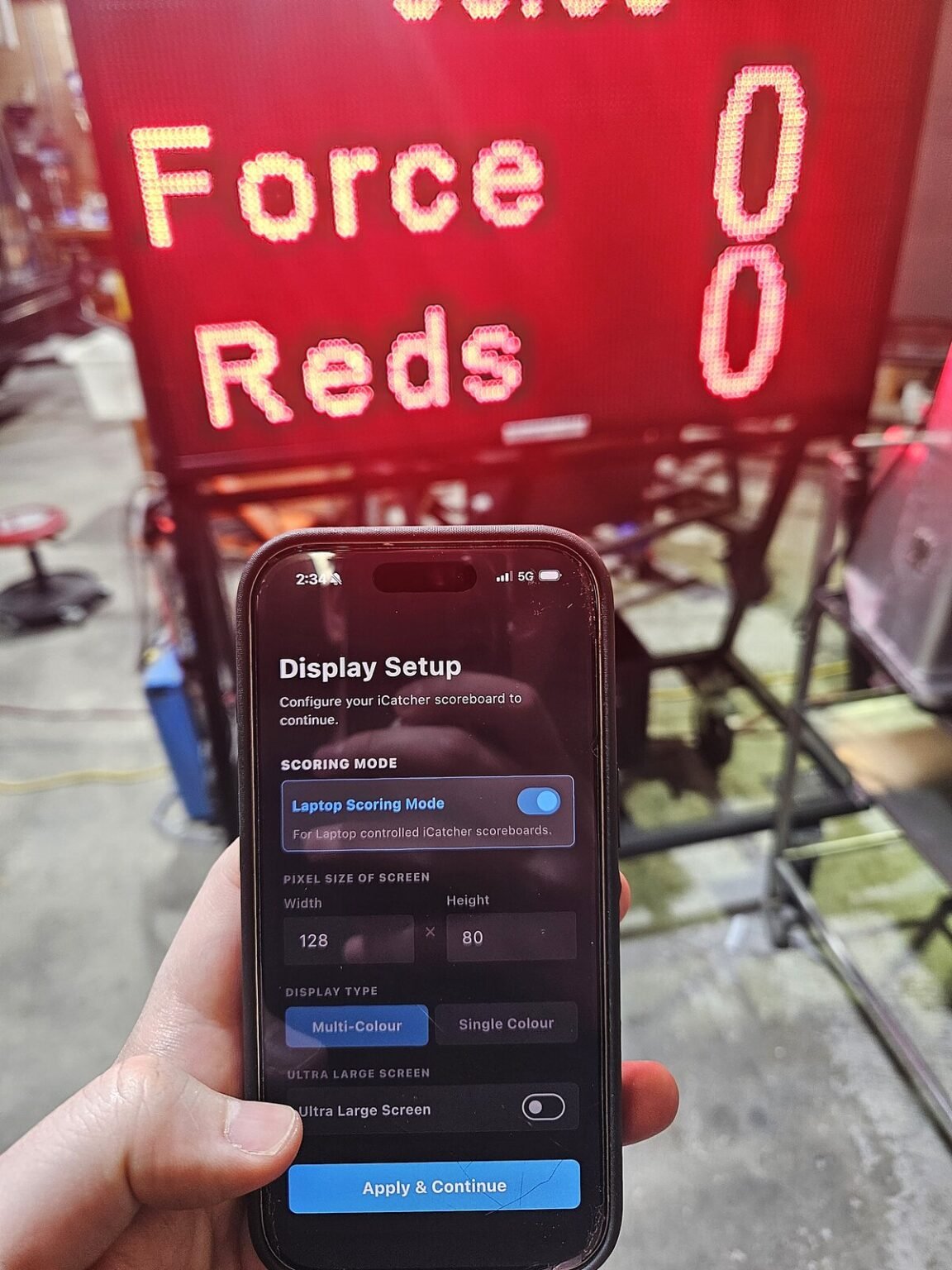 iCatcher Scoreboard app on a phone in front of a single-colour LED scoreboard